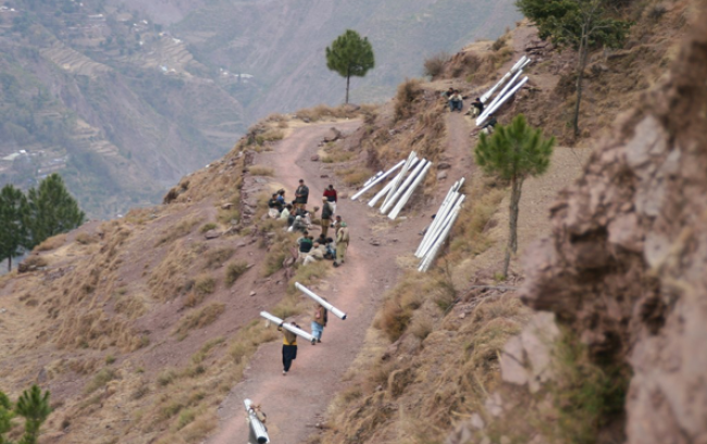 People carrying tin sheeting to rebuild after the earthquake